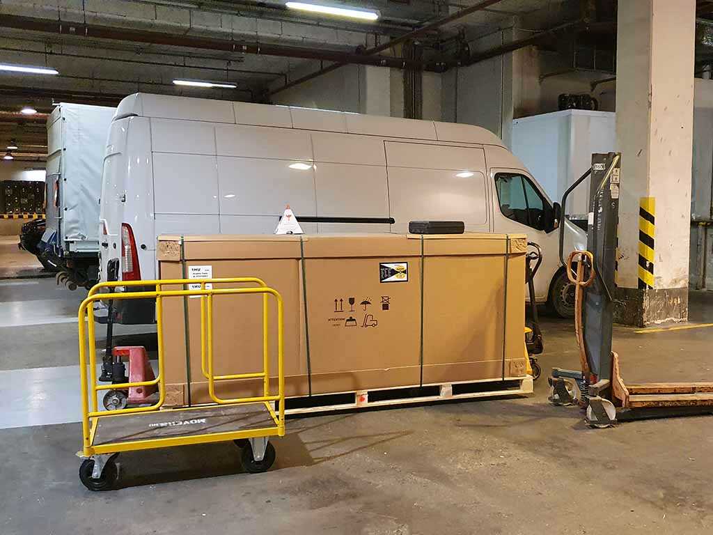 Raklapos áru mozgatása mélygarázsban, kisteherautó és kézi béka használatával – professzionális teherszállítás